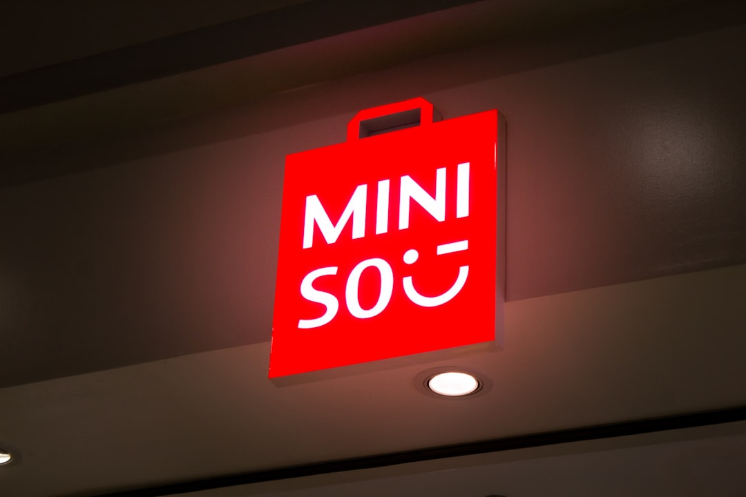 Red miniso store sign with shopping bag logo.